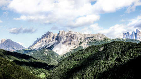 A high angle shot of green and rocky mountain range under the beautiful cloudy skyの写真素材