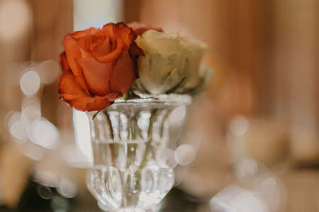 A selective focus shot of glass vase of roses on wedding table