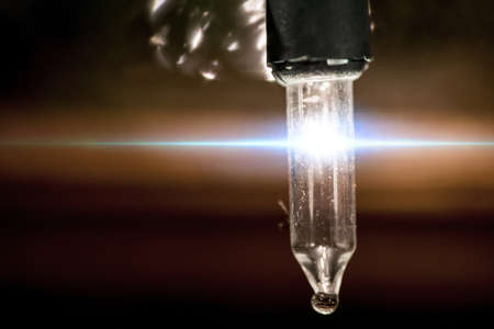 A horizontal lens flare penetrating through a small vertical light bulb