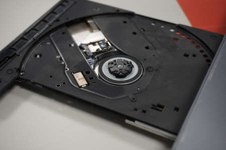 A closeup shot of open optical disc drive on a modern laptop computer without a disc