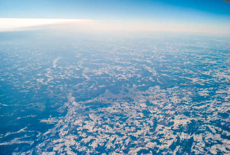 An aerial shot of a  snowy landscape taken from the airplaneの写真素材