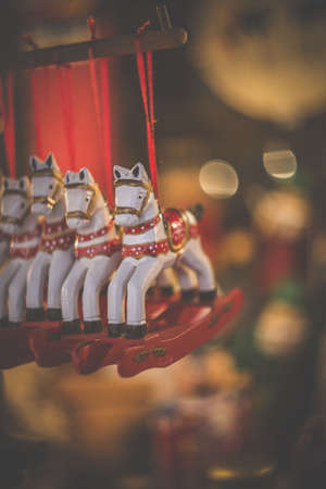 A selective focus shot of four cute horse carousel ornaments hanging inside the roomの写真素材