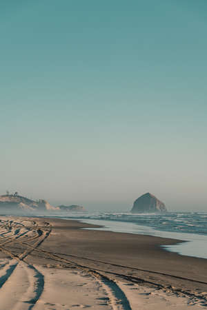 A beautiful shot of a sandy beach with amazing waves on a sunny day