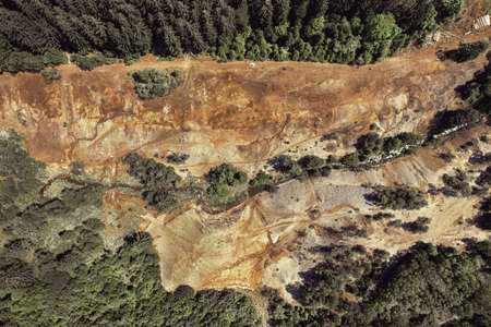 Drone photography of beautiful sand quarry surrounded by forest of the countryside on a sunny day