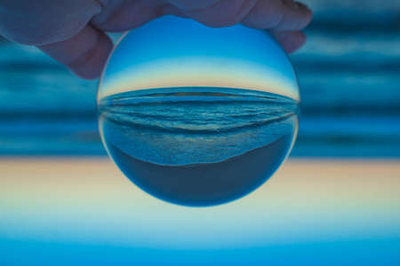 A beautiful creative shot of a beach with a crystal lens ballの写真素材