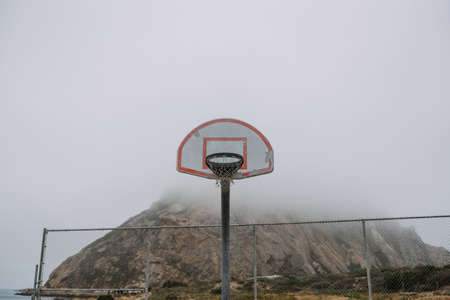 A shot of a basketball hoop on a backboard near mountainの写真素材