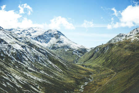 A beautiful shot of snowy mountains under a blue cloudy sky at daytime