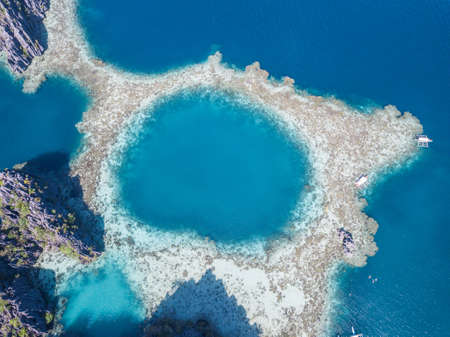 An aerial overhead shot of land surrounded by blue watersの写真素材