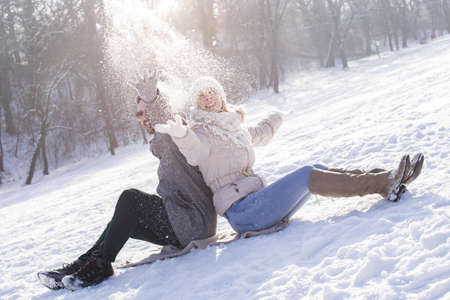 A shallow focus shot of a beautiful couple having fun during a snowy weatherの写真素材