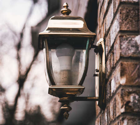 A shallow closeup shot of a street lantern on a stone wall