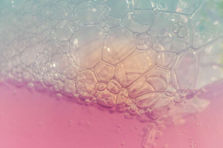 A closeup shot of a pink liquid substance with bubbles