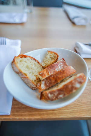 A vertical selective closeup shot of bread slices in a white bowl