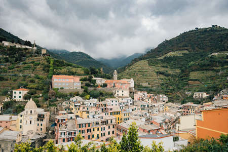 A high shot of a town with orange buildings located on green mountainsの写真素材