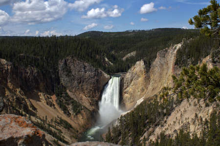 A landscape shot of a waterfall flowing from the cliffs of a mountain into a riverの写真素材
