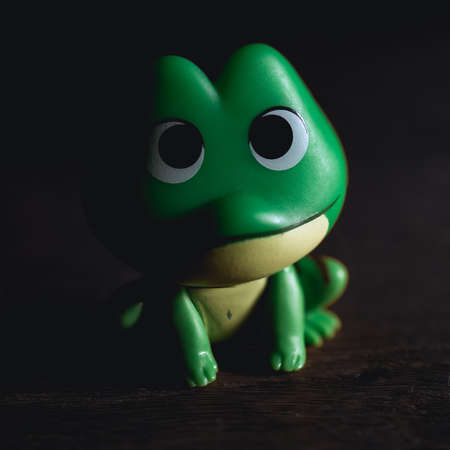 A vertical closeup shot of a small green frog toyの写真素材