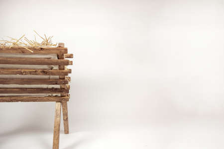 A beautiful shot of an isolated old wooden cradle with a stack of hay in it on a white backgroundの写真素材