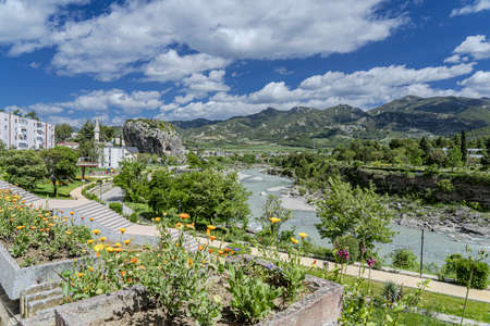 The image shows a view of the town of Permet on the Vjosa river in southern Albania