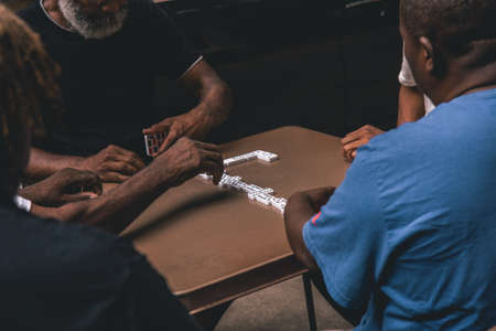 A shot of four African males playing domino on a table