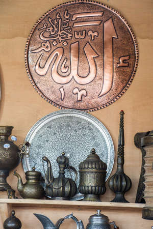 A vertical image of decorative brass jars and plates with the word "Allah" in Arabic calligraphyの写真素材