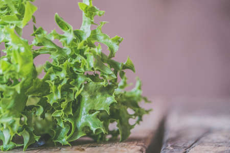 A closeup shot of edible grass ingredients for cooking on a wooden surfaceの写真素材