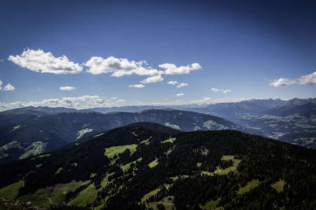 A beautiful high angle scenic shot of green mountains under the blue cloudy skyの写真素材