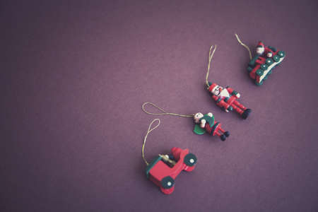 A high angle shot of Christmas tree hanging ornaments with a purple backgroundの写真素材