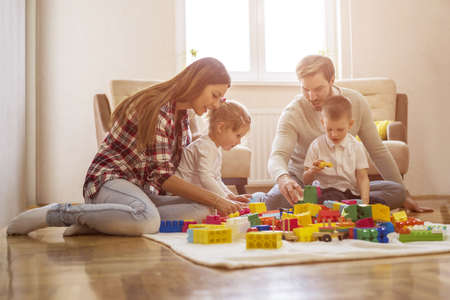Young Caucasian parents playing with their children at homeの写真素材
