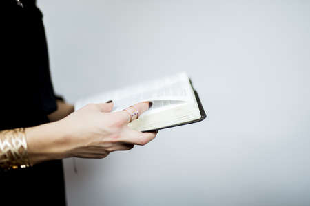 A selective focus closeup shot of a person reading a book on a white background