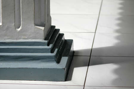 A selective closeup shot of the bottom of a blue and gray column on a gray floor