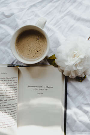 An overhead shot of a cup of coffee with a quote written on paper above