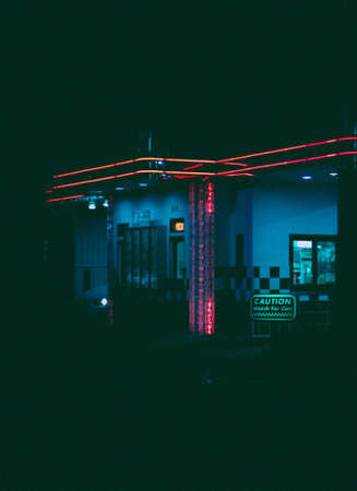 A vertical shot of a gas station with neon lights during nightの写真素材