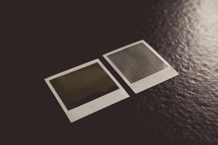 A high angle shot of two retro photo frames on a black surfaceの写真素材
