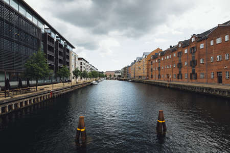 A beautiful shot of Kanal in the middle of city buildings under a cloudy skyの写真素材