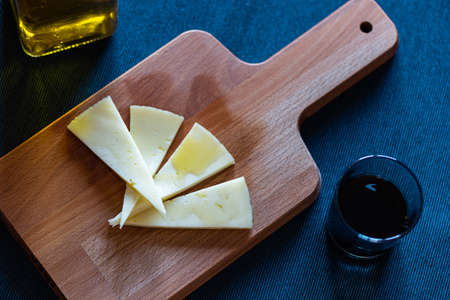 A closeup shot of triangular doughs on the cutting board next to oils