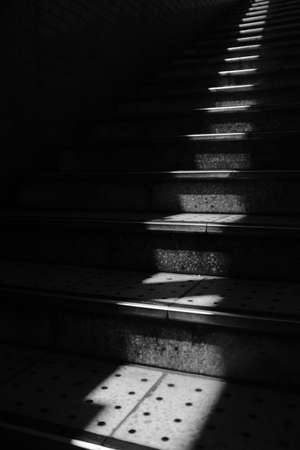 A grayscale vertical shot of stairs with holesの写真素材
