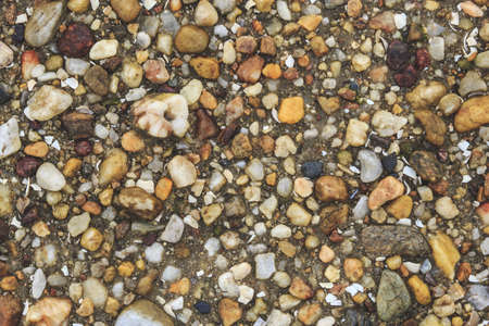 A high angle shot of the beautiful and colorful rocks and pebbles captured by a river