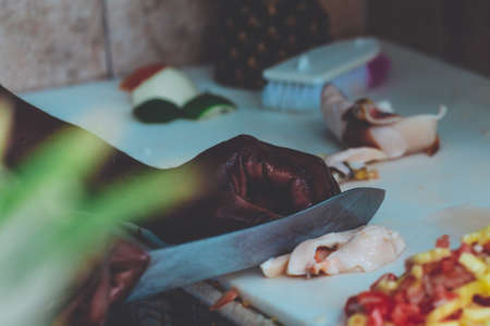 A closeup shot of an African male chopping meat