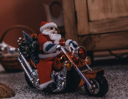 A closeup shot of a Santa Claus figurine on a motorcycleの写真素材