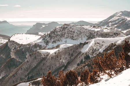 A bird's-eye view of snow-covered mountains under clear blue sky