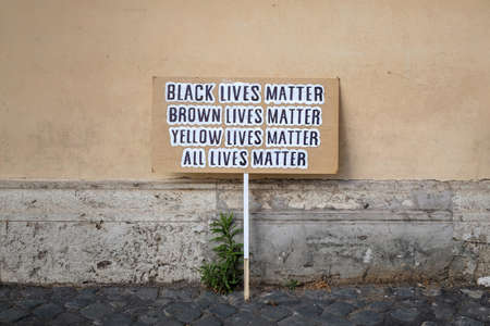 A paper board with "Black lives matter, ..., all lives matter" writings on itの写真素材