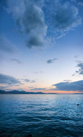 A vertical shot of a beautiful sea under a blue cloudy sky