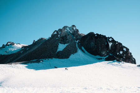 A beautiful shot of rocky snowy mountains under the beautiful blue skyの写真素材