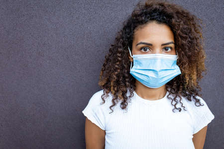 A young Hispanic female wearing a facemask under the lights - COVID-19の写真素材