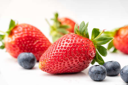 A selective closeup shot of ripe strawberries and blueberriesの写真素材