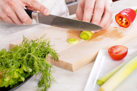 A closeup shot of a male preparing a fresh vegetable salad in the kitchen