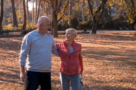 An active senior couple exercising outside in the park on a beautiful sunny day