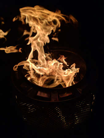 A vertical closeup shot of a fire flame burning inside of a pot