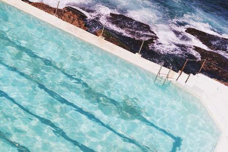 A beautiful shot of a  pool near rocks and the sea