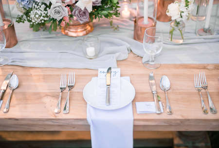 A high angle shot of a decorated wedding table setting with invitations in white platesの写真素材
