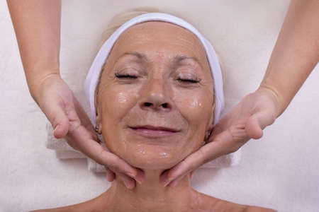 A professional taking care of an ender female's face and skinの写真素材